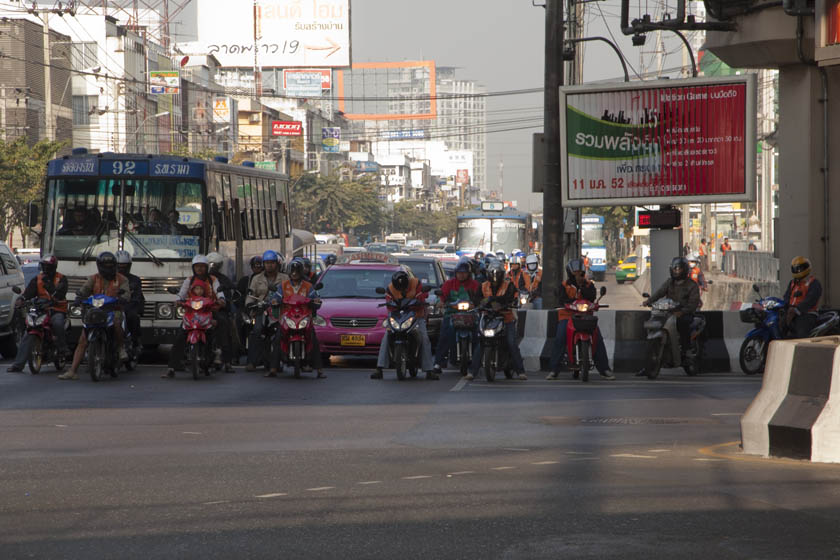 Bangkok motorcycle taxi drivers wait at a light