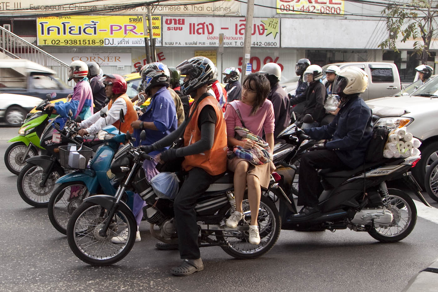 Bangkok motorcycle taxi and passenger wait at a light